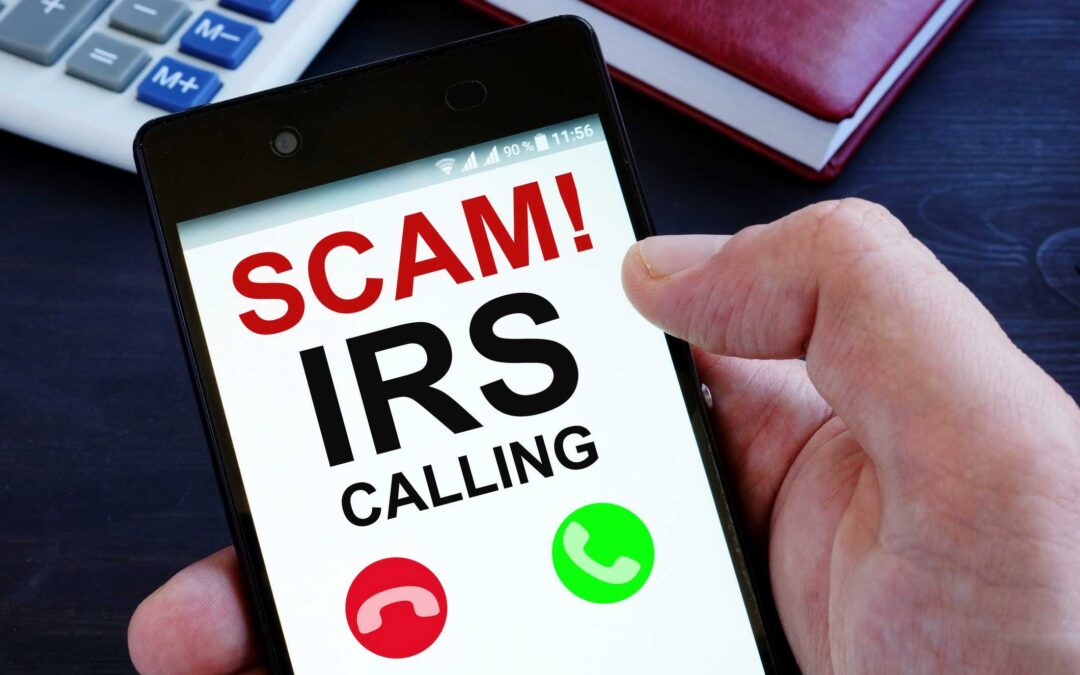 Mobile phone screen reads SCAM! IRS Calling