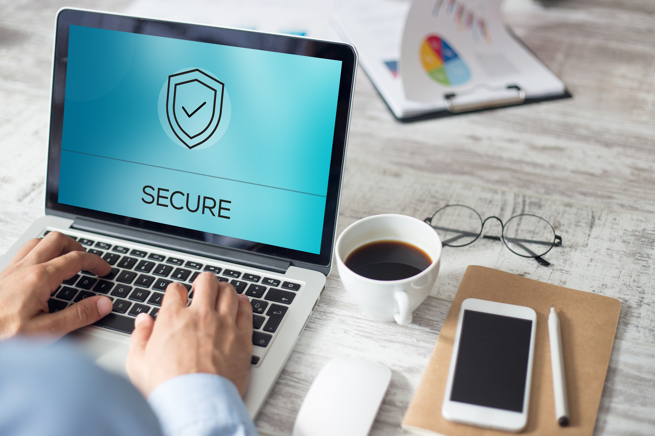 Man typing on a laptop with the word Secure on the screen.