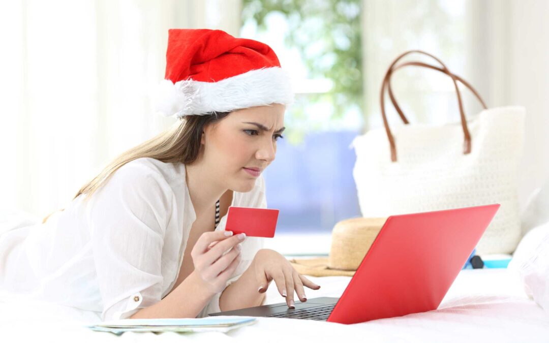 A woman wearing a Santa hat shopping online.