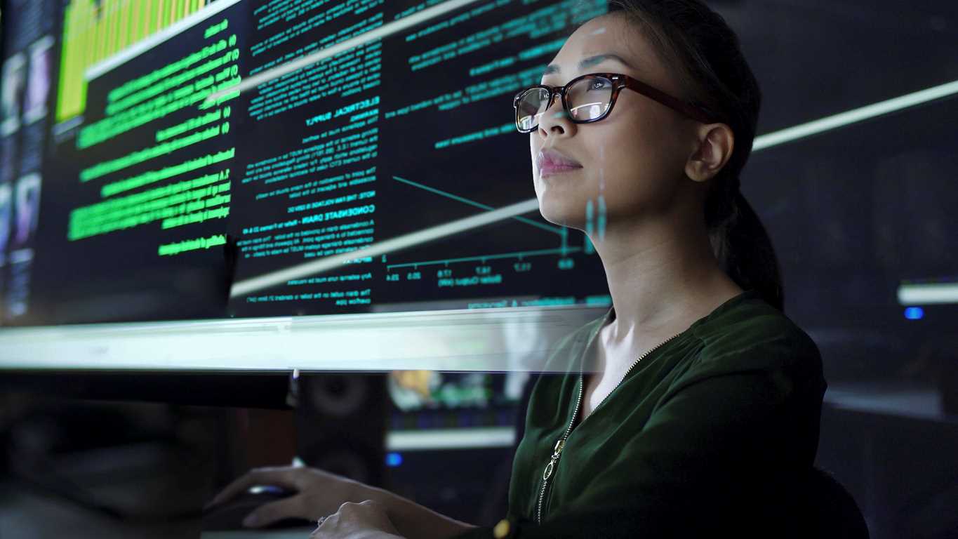 A woman is viewing data on a large screen.