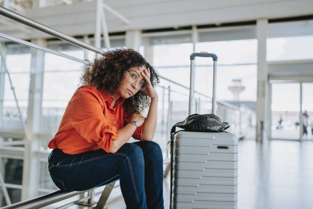 Upset woman in an airport experiencing a travel scam