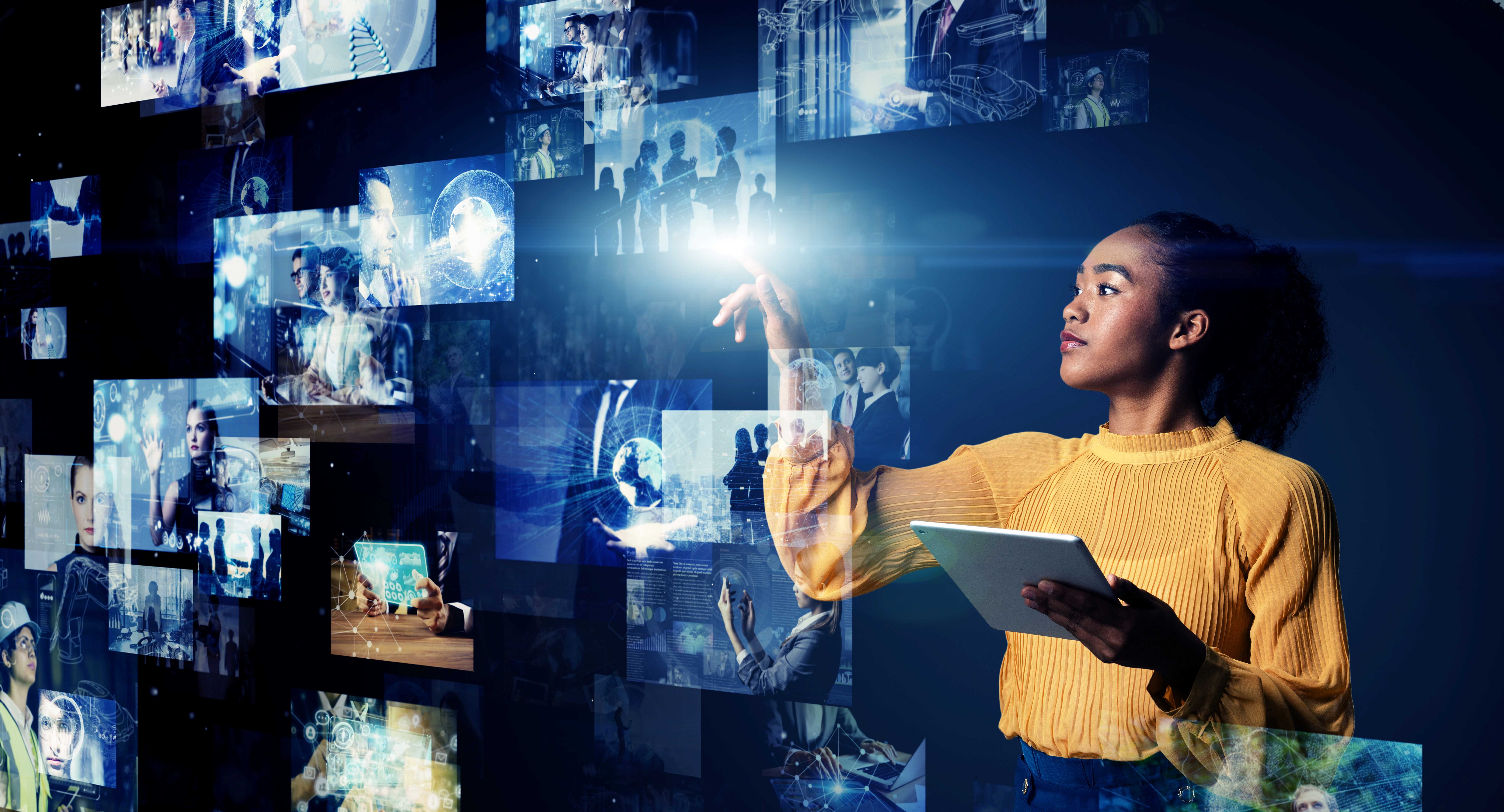 Woman holding a tablet computer and looking at photos stored in the Cloud.