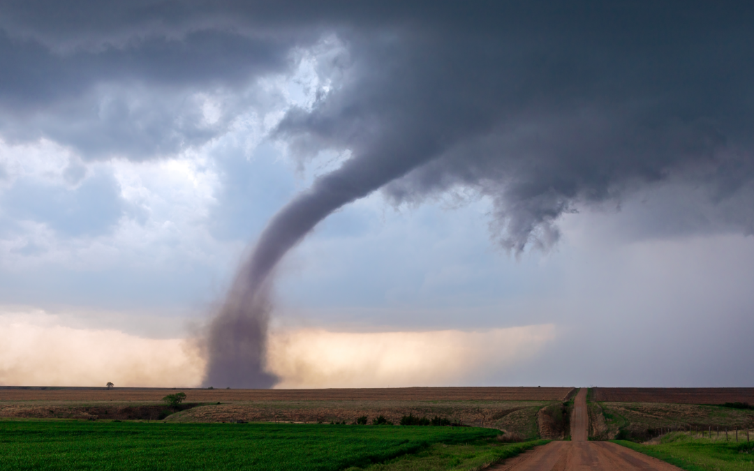 A tornado touching down in a rural farm area.