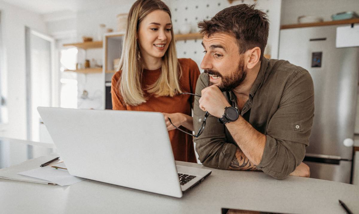 Couple researching credit freezes using a laptop