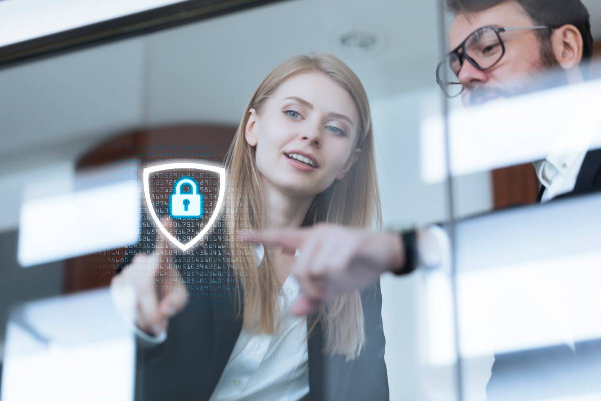 Businessman and woman touching data protection shield