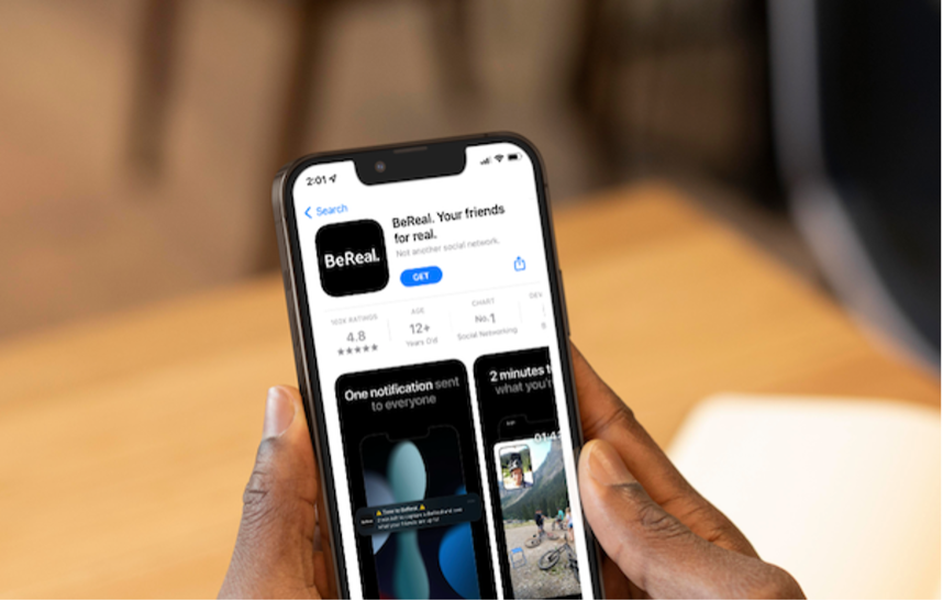Man holding a smartphone & viewing the BeReal app available to download.
