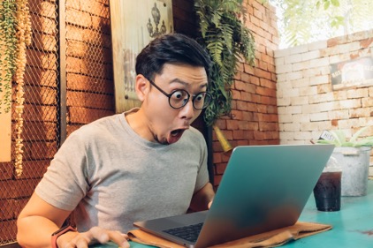 Shocked man looking at his old social media posts.