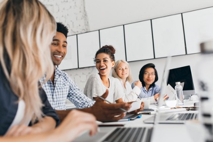 5 young co-workers in an office meeting.