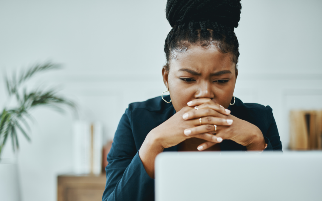 Concerned looking woman viewing email spam on her laptop computer