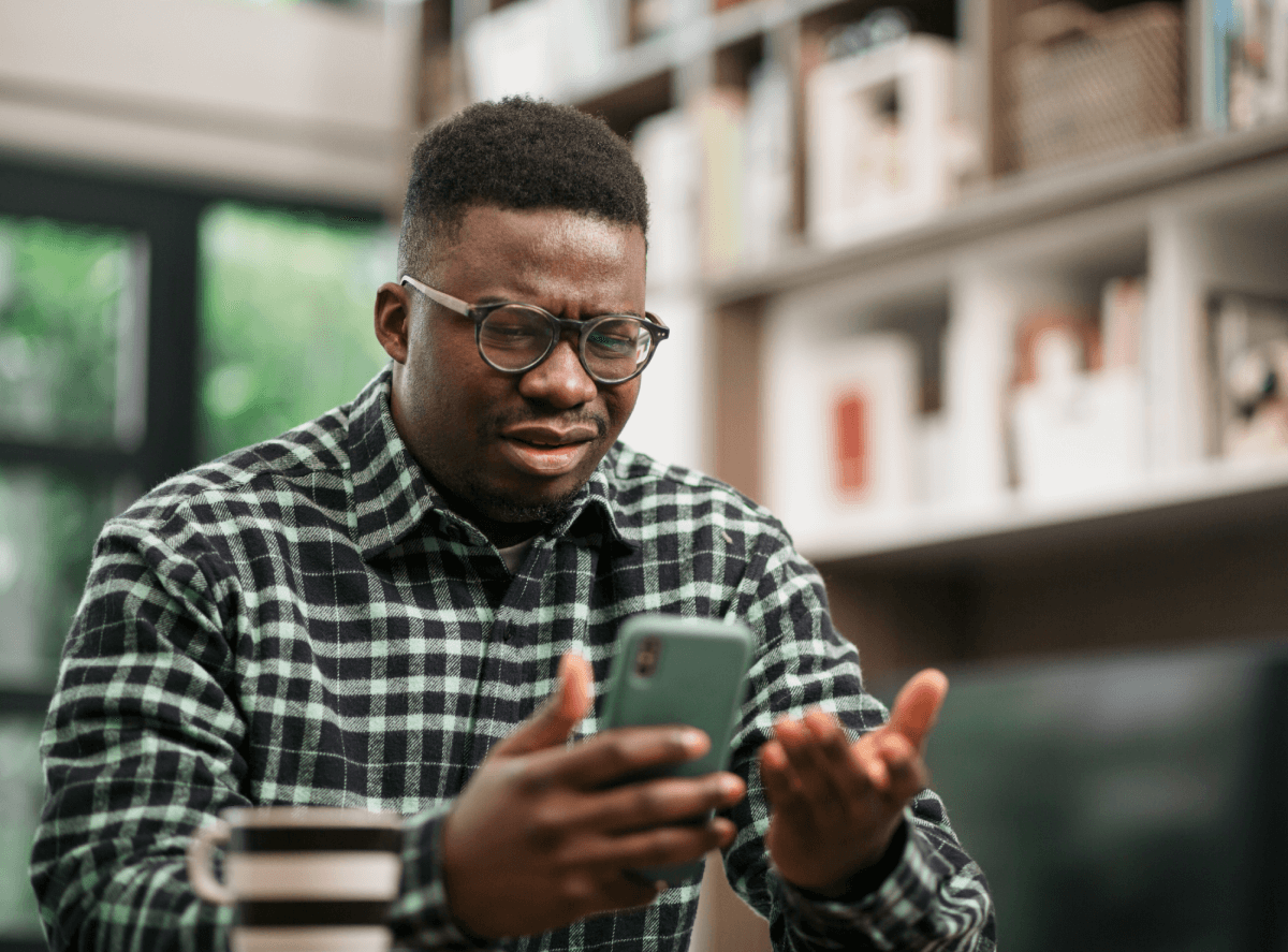 Man realizing his mobile phone has been hacked.