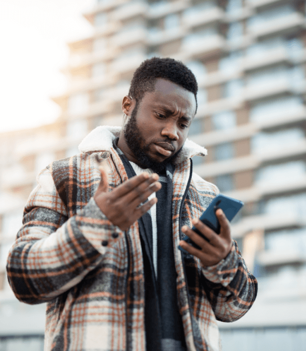 Man wearing a coat outside frustrated that his mobile phone may have been hacked.