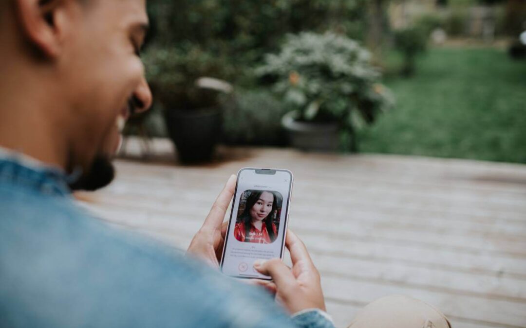 Man looking at a woman's photo on his phone via a dating app