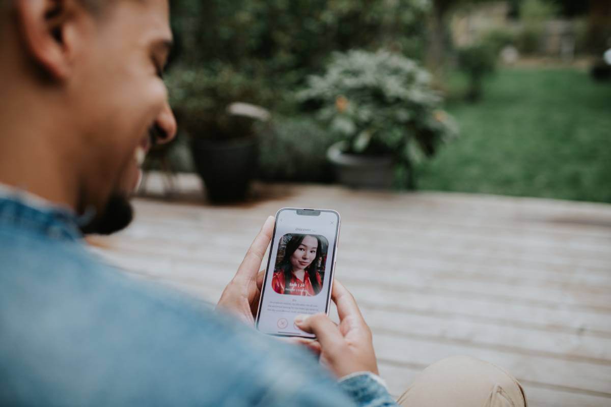 Man looking at a woman's photo on his phone via a dating app