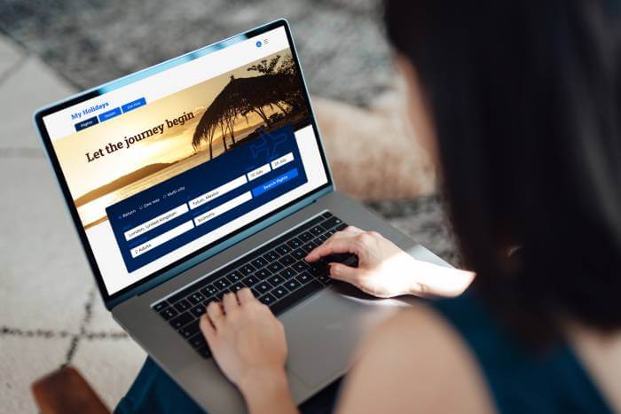 Woman shopping on a laptop for wedding travel while practicing cybersecurity wedding planning.