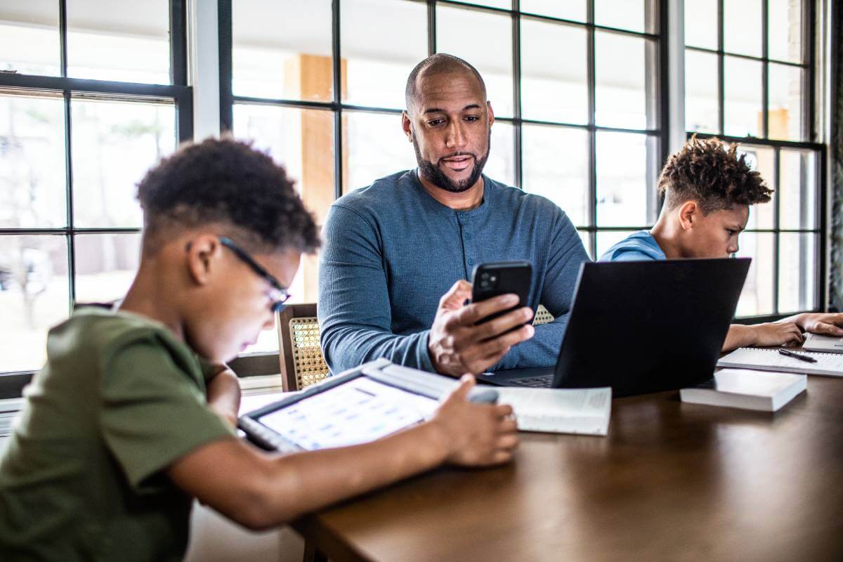 Father and sons doing social media cleanse on their devices.