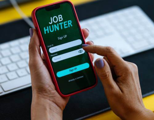 Job Hunter login screen of a smartphone held by a college student.