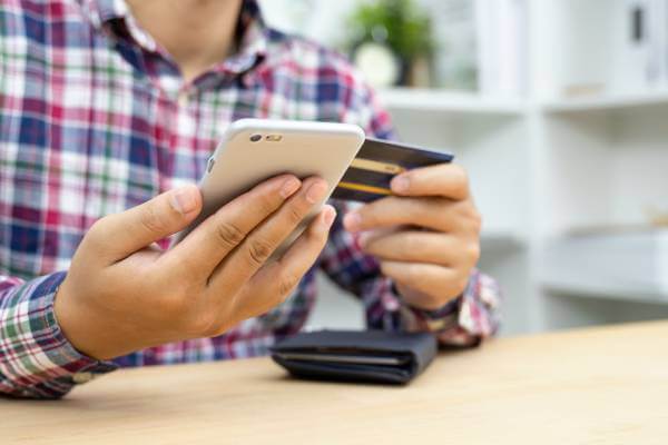 Man using phone payment app with his credit card.